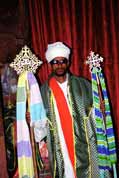 Stone church at Lalibela. Priest shows holy crosses. Ethiopia.