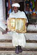 Priest shows old Bible made from goat skin. Ethiopia.