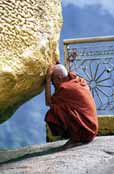 Monk prayes at holy stupa at Kyaiktiyo. Myanmar (Burma).