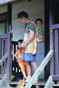 Dayak man is carrying baby in Sungai Barang village. Kalimantan,  Indonesia.