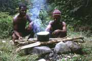 Guides are cooking lunch during trekking. Papua, Indonesia.