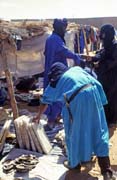 Tuaregs at market. One of them is watching salt plates. They have been transported to Djbok village from middle of Sahara, from salt mines at Taoudenni. Mali.